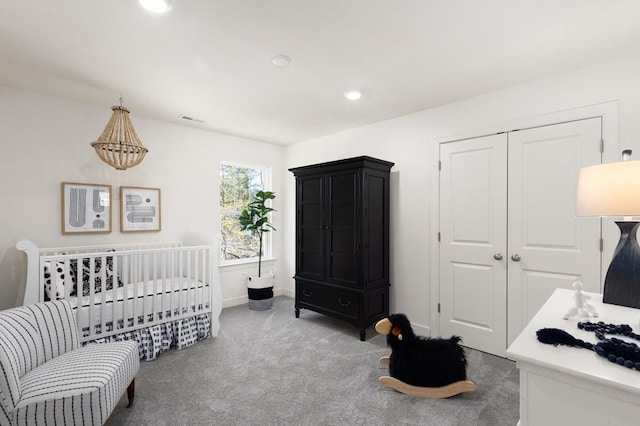 bedroom featuring carpet flooring, a closet, and a nursery area