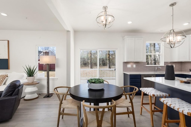 dining room with sink, a wealth of natural light, and a chandelier