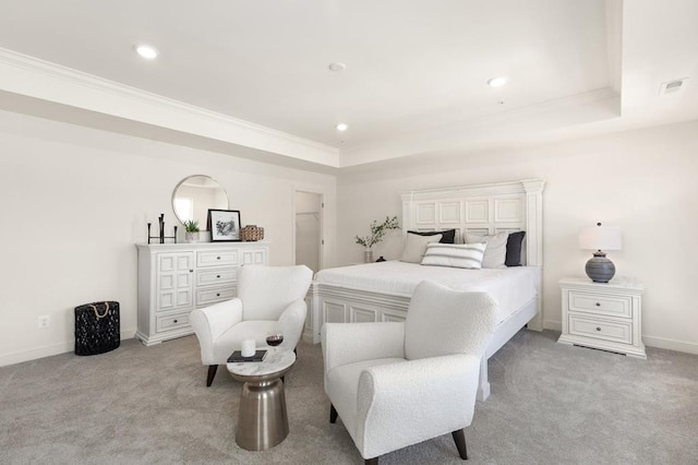 carpeted bedroom with a tray ceiling and crown molding