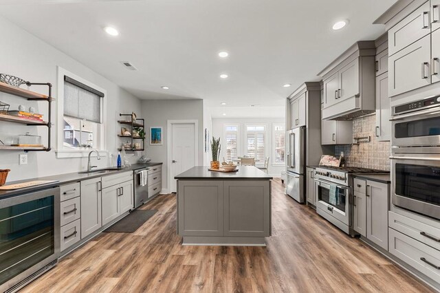 kitchen featuring gray cabinets, a kitchen island, dark wood-type flooring, and appliances with stainless steel finishes