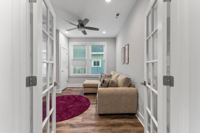 living area with dark hardwood / wood-style flooring, ceiling fan, and french doors