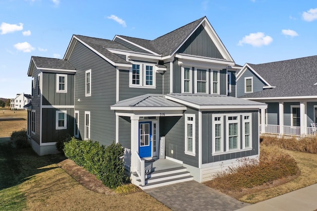 view of front facade with board and batten siding and roof with shingles