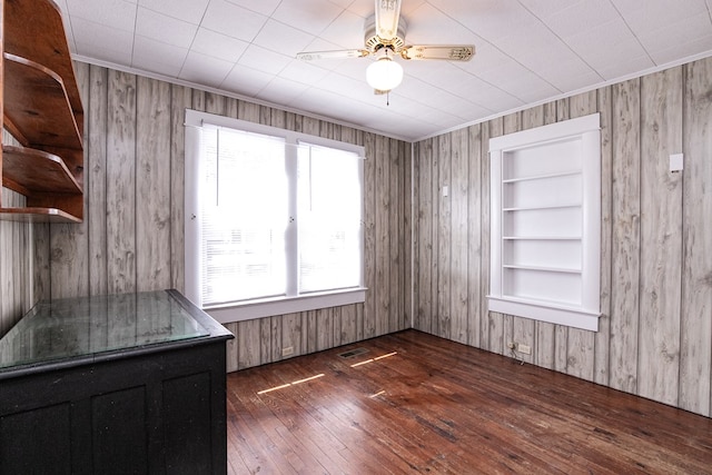 24103 Adelaide St, Parksley, VA 23421 - unfurnished dining area with hardwood / wood-style floors, built in shelves, wooden walls, a ceiling fan, and ornamental molding
