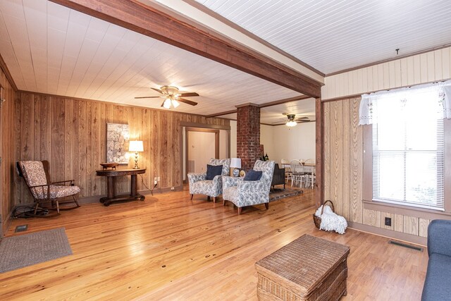 24103 Adelaide St, Parksley, VA 23421 - living room featuring ceiling fan, decorative columns, wood finished floors, wood walls, and crown molding