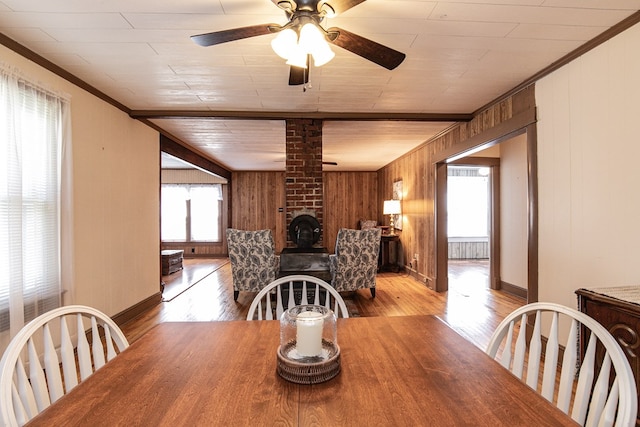 24103 Adelaide St, Parksley, VA 23421 - dining room featuring wood finished floors, wooden walls, a ceiling fan, and ornamental molding