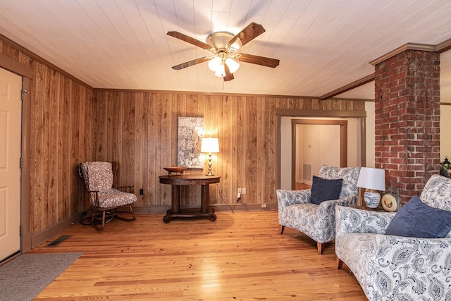 24103 Adelaide St, Parksley, VA 23421 - living area with ceiling fan, wood walls, wood-type flooring, and crown molding