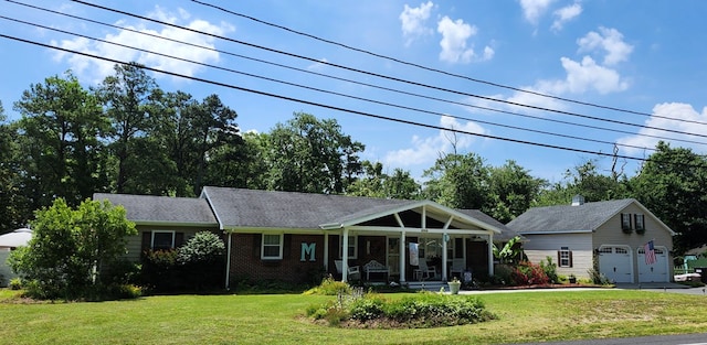 view of front of property featuring a garage, covered porch, and a front yard