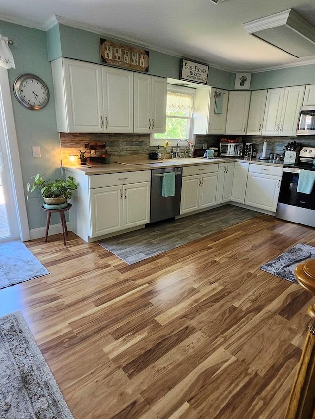 kitchen with sink, white cabinetry, stainless steel appliances, and light hardwood / wood-style flooring