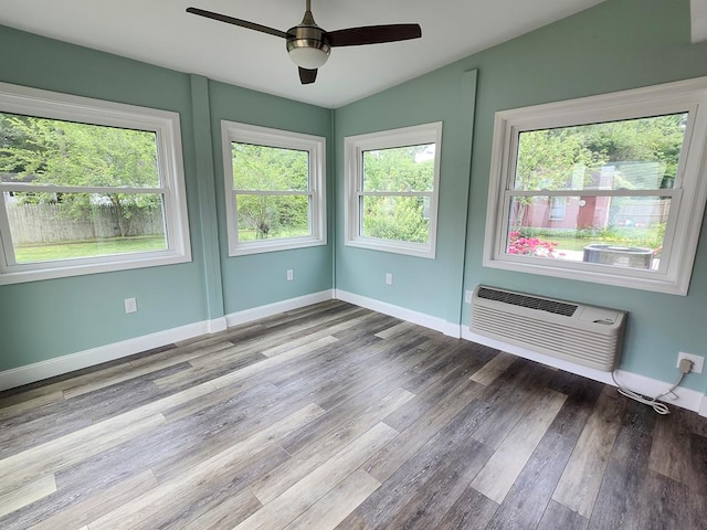 4068 Ridge Rd, Chincoteague, VA 23336 - spare room featuring wood finished floors, a wall mounted AC, a ceiling fan, lofted ceiling, and baseboards