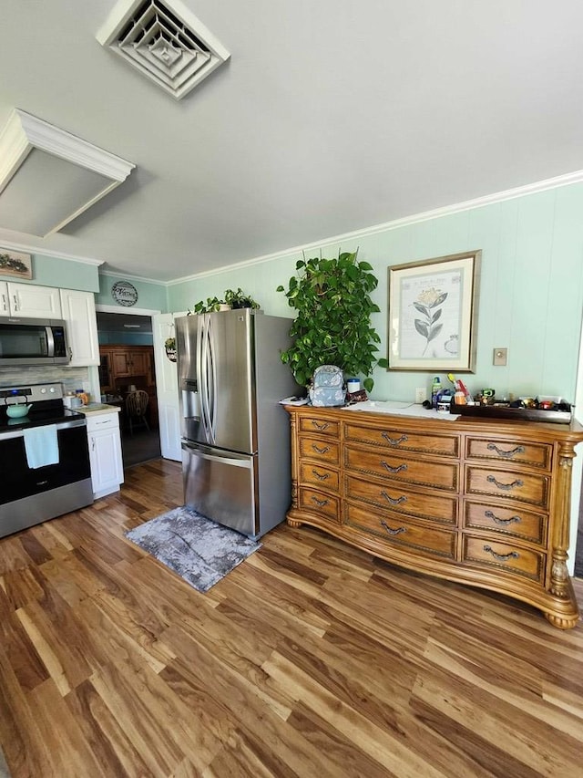 kitchen with crown molding, white cabinets, dark hardwood / wood-style floors, and appliances with stainless steel finishes