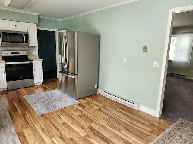 4068 Ridge Rd, Chincoteague, VA 23336 - kitchen with appliances with stainless steel finishes, a baseboard heating unit, light countertops, crown molding, and white cabinetry