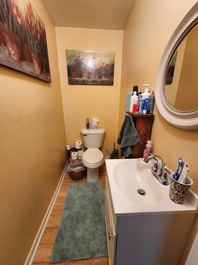 bathroom featuring toilet, vanity, and hardwood / wood-style flooring