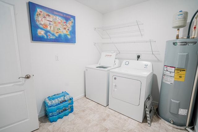 laundry area with water heater, baseboards, laundry area, and washing machine and dryer