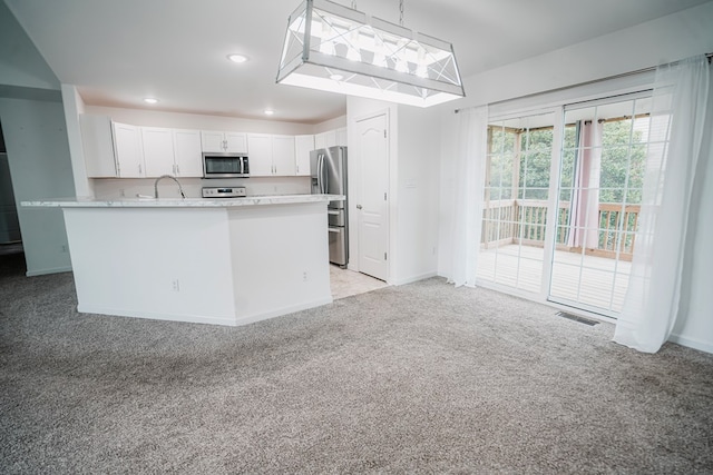 kitchen with white cabinetry, visible vents, stainless steel appliances, baseboards, and light carpet