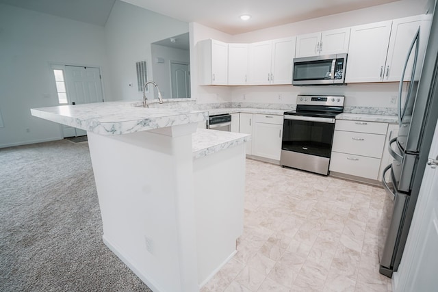 kitchen with a sink, white cabinets, stainless steel appliances, and light countertops