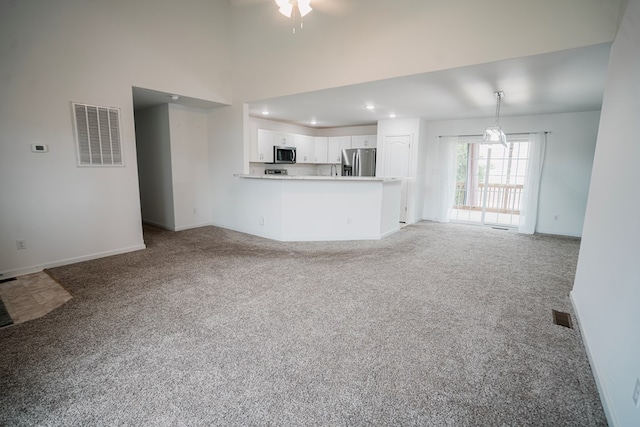 unfurnished living room featuring baseboards, visible vents, a ceiling fan, and light carpet