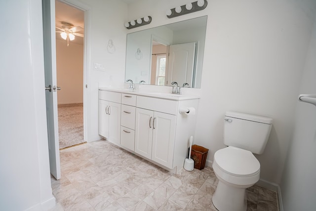 full bath with toilet, baseboards, a ceiling fan, and a sink