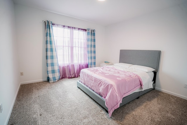 bedroom with baseboards and carpet
