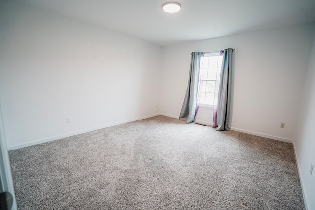 carpeted empty room with visible vents and baseboards