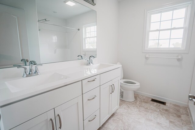 full bath featuring visible vents, toilet, double vanity, and a sink