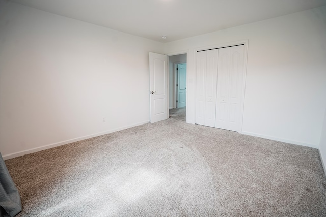 unfurnished bedroom featuring a closet, carpet, and baseboards