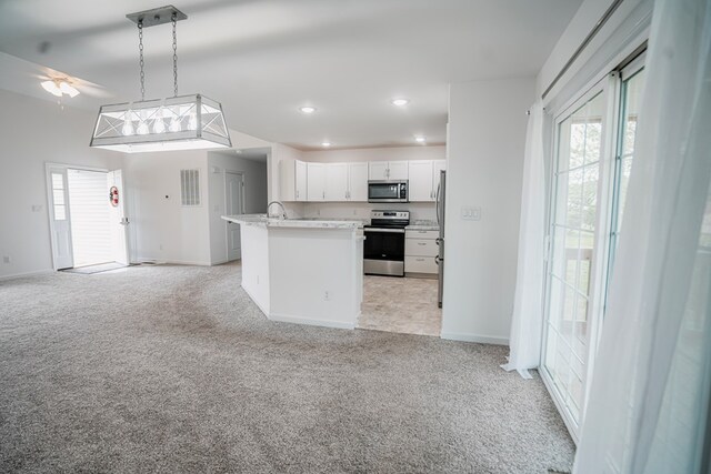 kitchen with ceiling fan, light carpet, white cabinets, appliances with stainless steel finishes, and open floor plan
