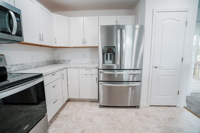 kitchen featuring light stone countertops, white cabinets, and stainless steel appliances