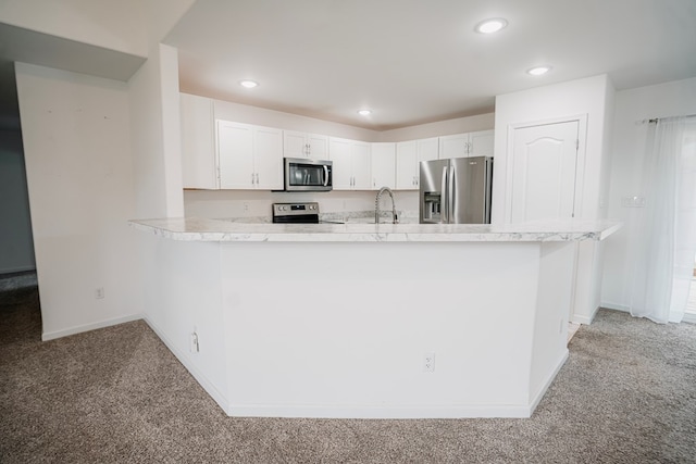 kitchen with baseboards, light carpet, appliances with stainless steel finishes, and light countertops