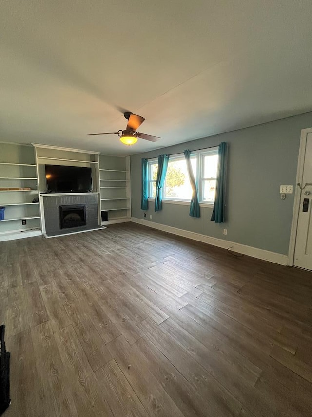 unfurnished living room featuring hardwood / wood-style floors, ceiling fan, and a fireplace