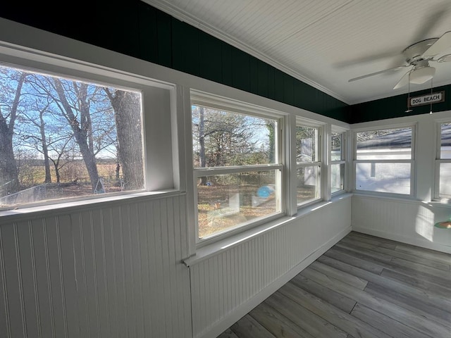 unfurnished sunroom with ceiling fan