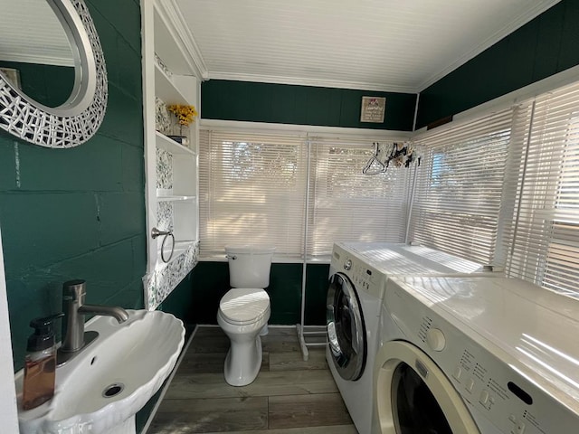 bathroom with toilet, washer and clothes dryer, ornamental molding, and sink