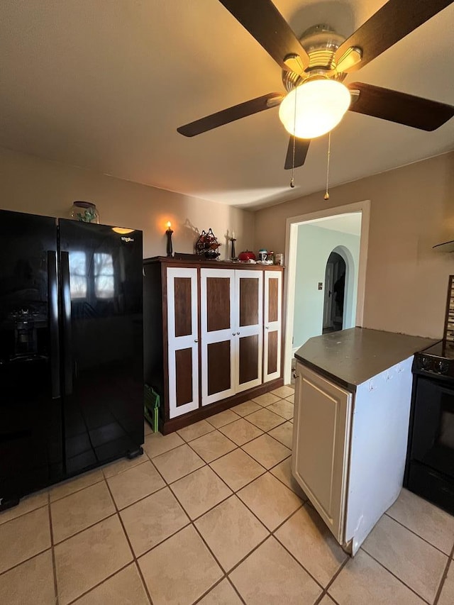 kitchen featuring white cabinetry, light tile patterned floors, black appliances, and ceiling fan