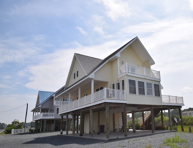 back of property with a balcony and a patio