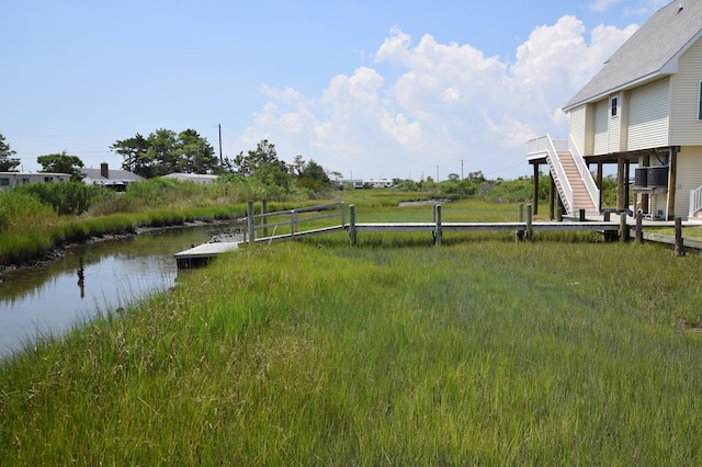 view of yard featuring a water view and a dock