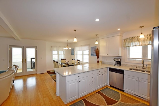 kitchen featuring kitchen peninsula, stainless steel appliances, white cabinets, and sink