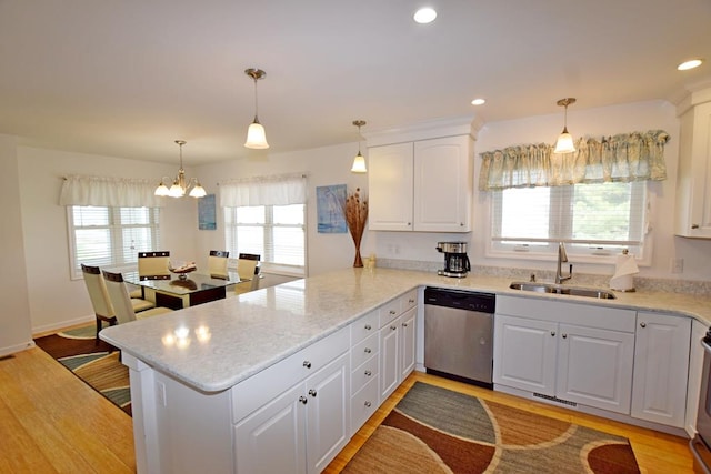 kitchen with white cabinetry, sink, stainless steel dishwasher, kitchen peninsula, and pendant lighting