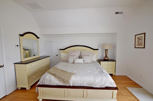 bedroom featuring light hardwood / wood-style floors and lofted ceiling