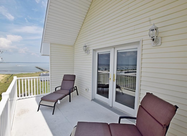 balcony with a water view and french doors