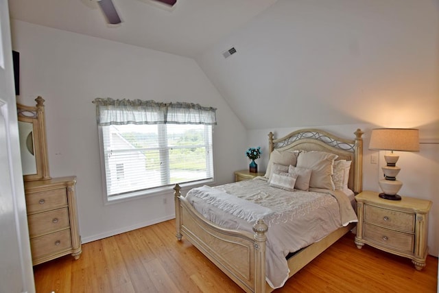 bedroom featuring light hardwood / wood-style floors, vaulted ceiling, and ceiling fan