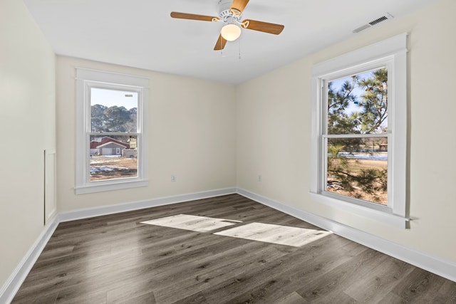 empty room with dark wood-type flooring and ceiling fan