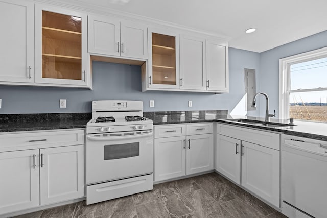 kitchen featuring white cabinetry, sink, dark stone countertops, and white appliances