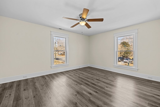 unfurnished room featuring ceiling fan, a healthy amount of sunlight, and dark hardwood / wood-style flooring