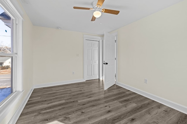 unfurnished room with dark wood-type flooring, ceiling fan, and plenty of natural light