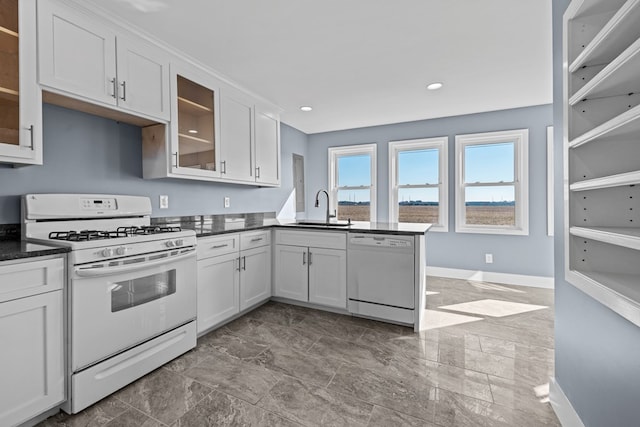 kitchen featuring white cabinetry, sink, and white appliances