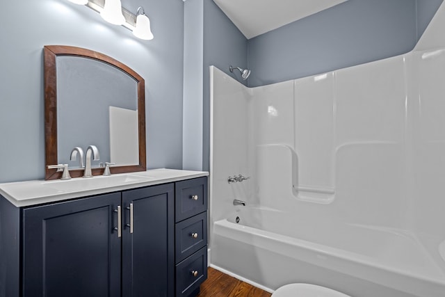 bathroom with washtub / shower combination, vanity, and hardwood / wood-style floors