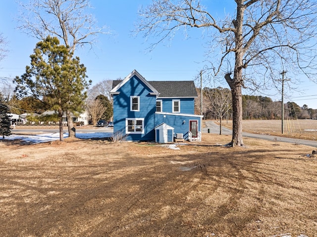 view of front of house featuring cooling unit and a front yard