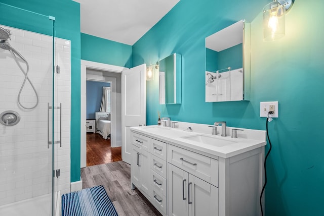 bathroom featuring hardwood / wood-style floors, vanity, and a shower with door