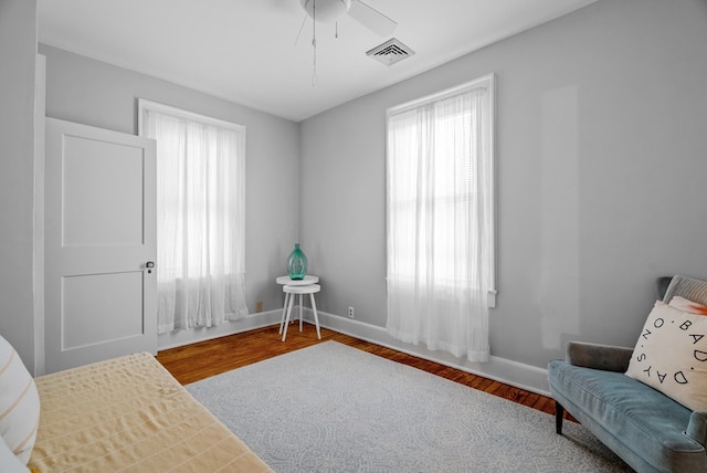 sitting room with ceiling fan and wood-type flooring