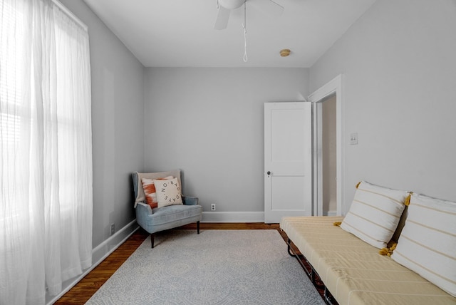 living area with hardwood / wood-style floors and ceiling fan