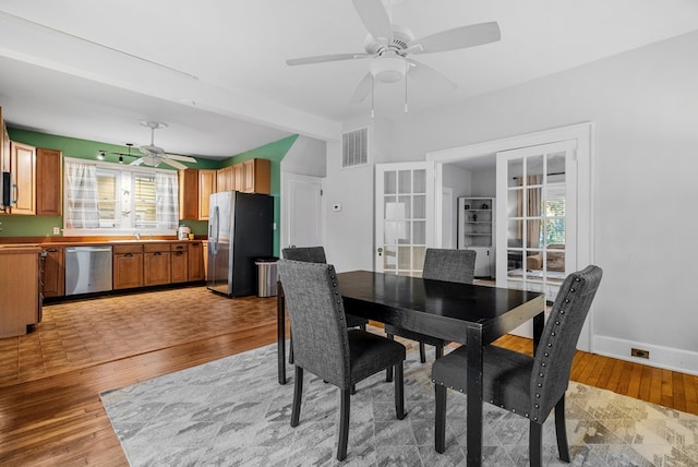 dining room featuring ceiling fan, plenty of natural light, french doors, and light wood-type flooring